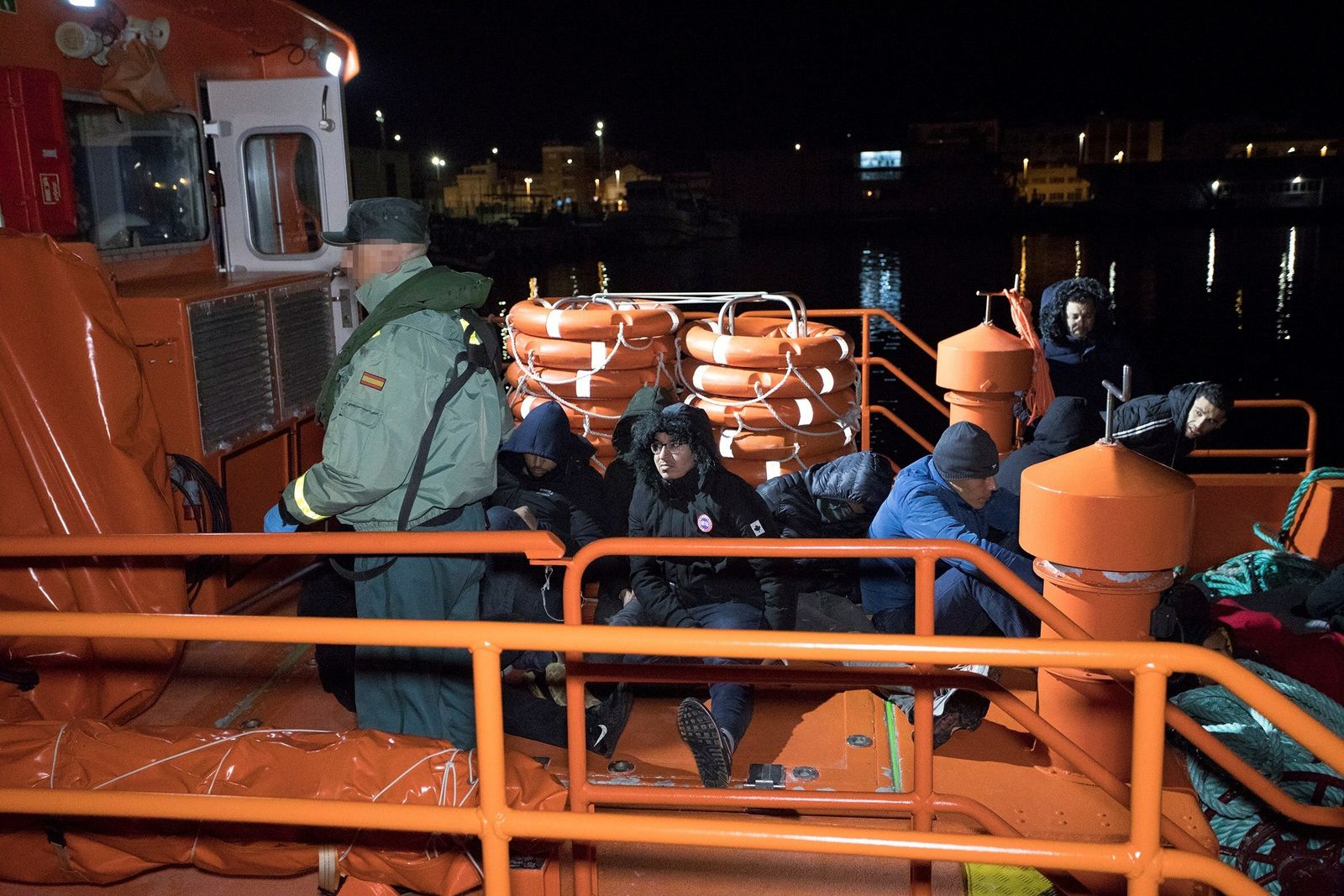 Un agente de la Guardia Civil junto a varios de los inmigrantes rescatados.