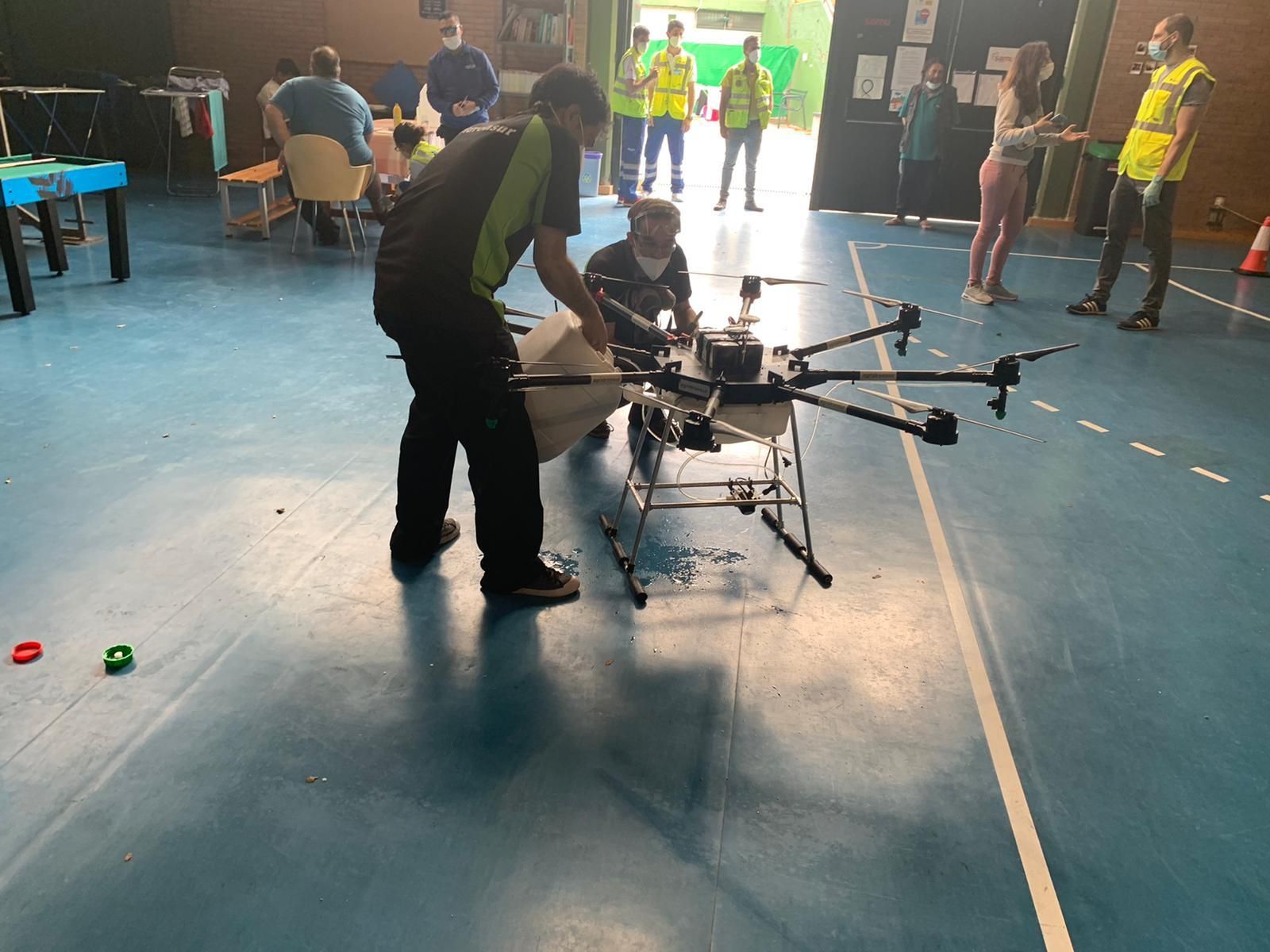 Los técnicos preparan el dron para la desinfección del centro de personas sin hogar de Rochelambert.