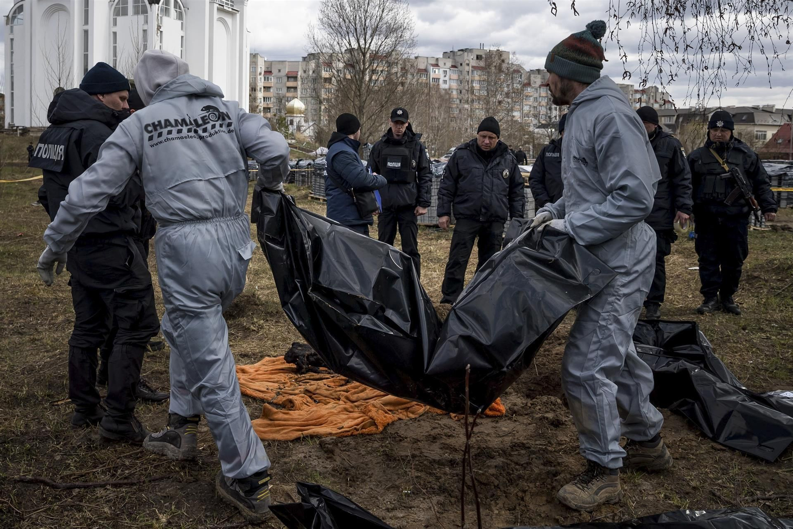 Personal forense trabaja en la zona donde han encontrado una fosa común detrás de la iglesia St Andrew Pervozvanno, en Bucha (Ucrania).
