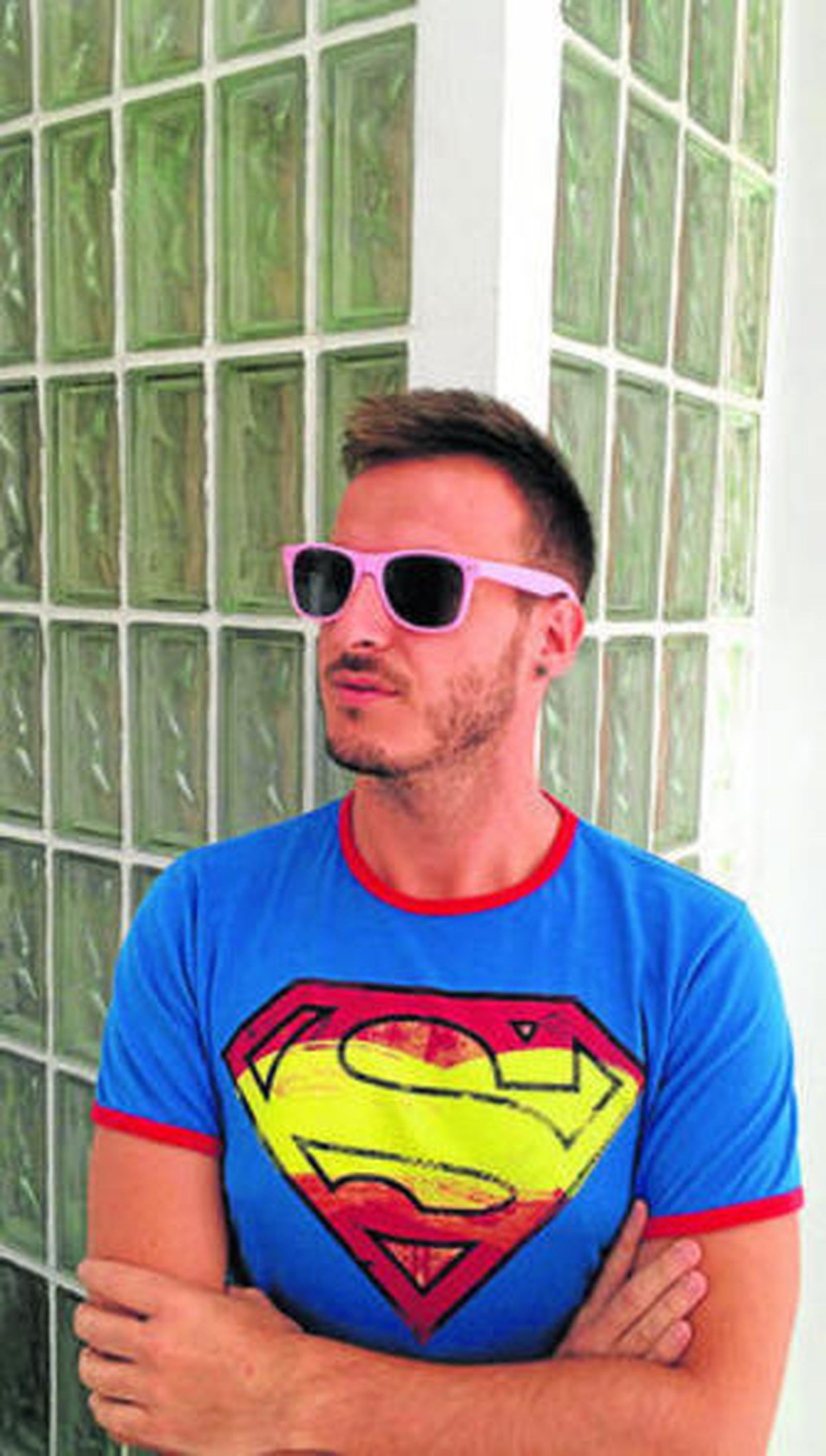 Un joven se coloca las gafas rosas por el cáncer de mama.