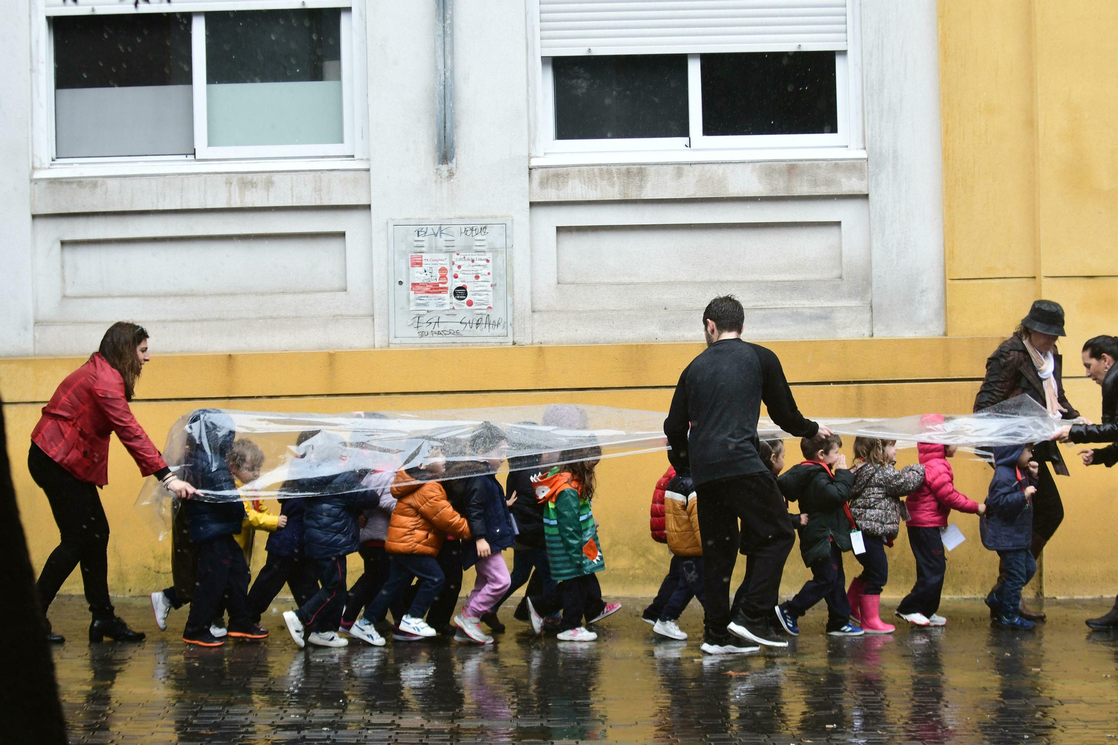 Escolares se protegen de la lluvia durante una salida.
