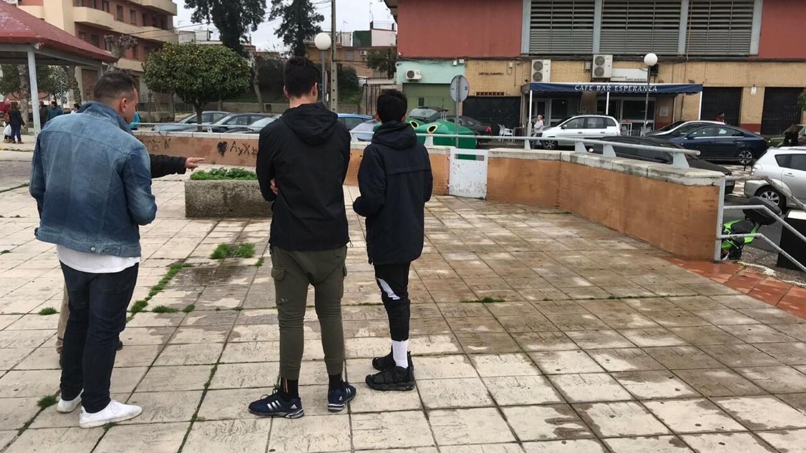 Varios vecinos muestran la zona en la que fue localizado el cadáver en la Plaza de Blas Infante en San Juan.