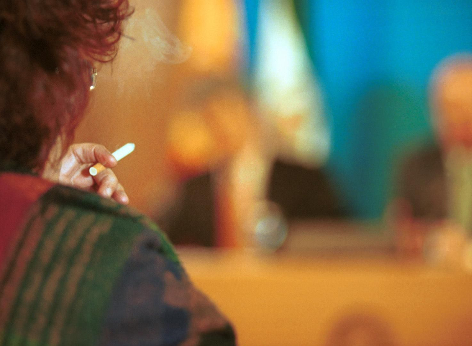 Una mujer fumándose un cigarrillo.