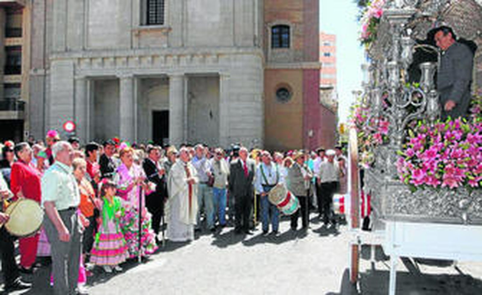 Los rocieros contemplan a Pedro Martínez, alcalde de carretas, mientras coloca el Simpecado.