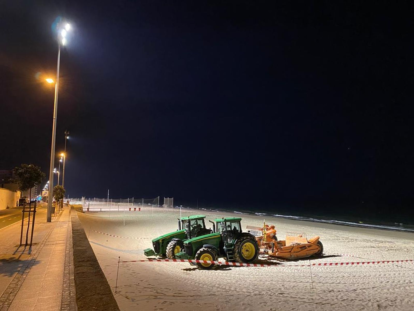 La playa de la Victoria de Cádiz, iluminada en su tramo cercano al cementerio.