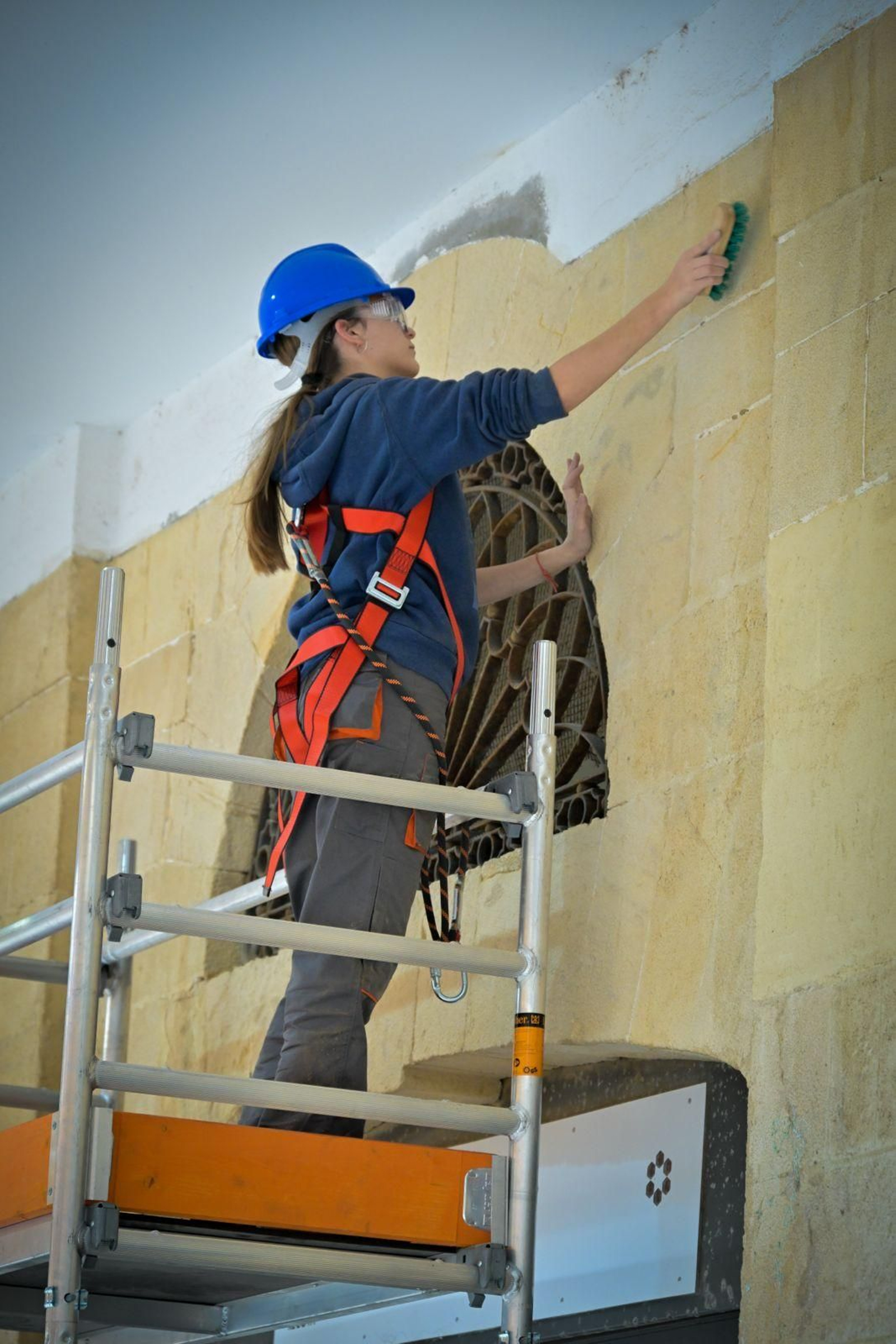 Una operaria trabaja en la rehabilitación de la fachada de los puestos del Mercado Central de Cádiz.