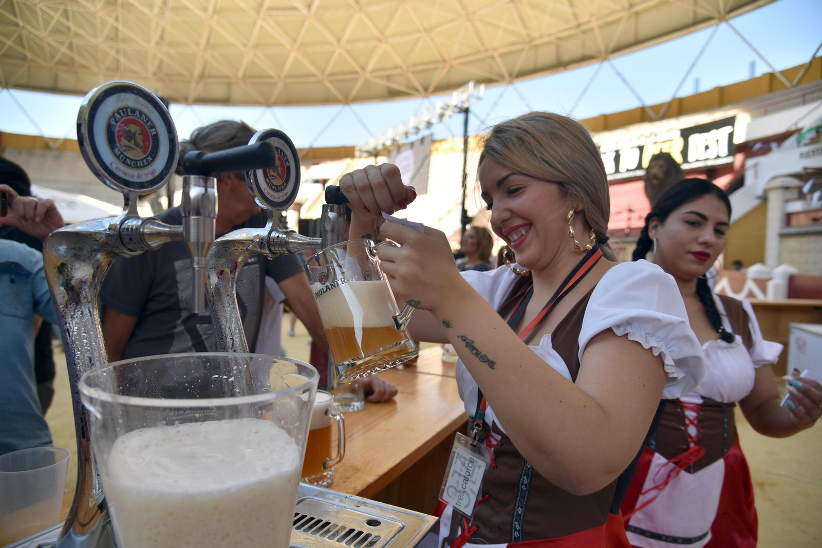 Una joven llena una jarra de cerveza en el Oktobeerfest 2018 de Los Barrios.
