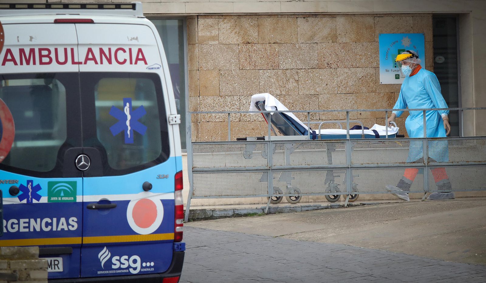 Un sanitario recibe con una camilla a un paciente que ha llegado en ambulancia.