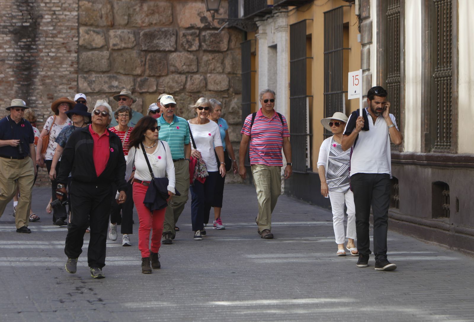 Visitantes siguen a un guía turístico por la zona monumental de la capital