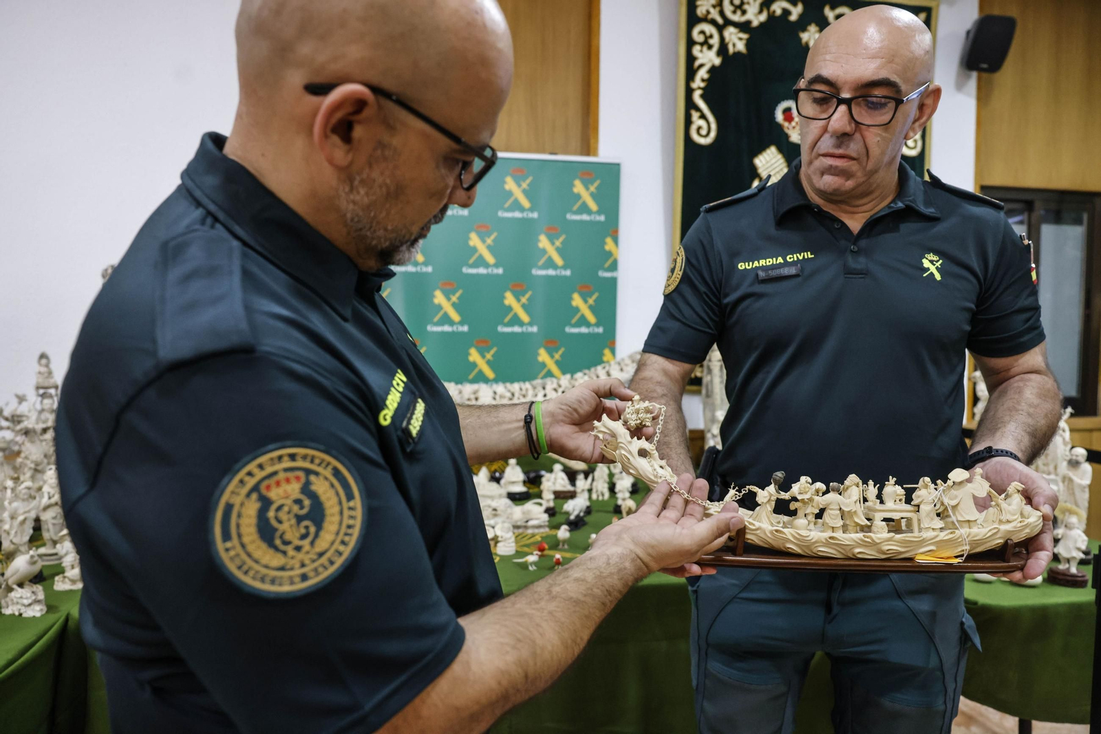 Dos agentes de la Guardia Civil muestran una de las mayores incautaciones de piezas de marfil de España en la comandancia de Valencia.