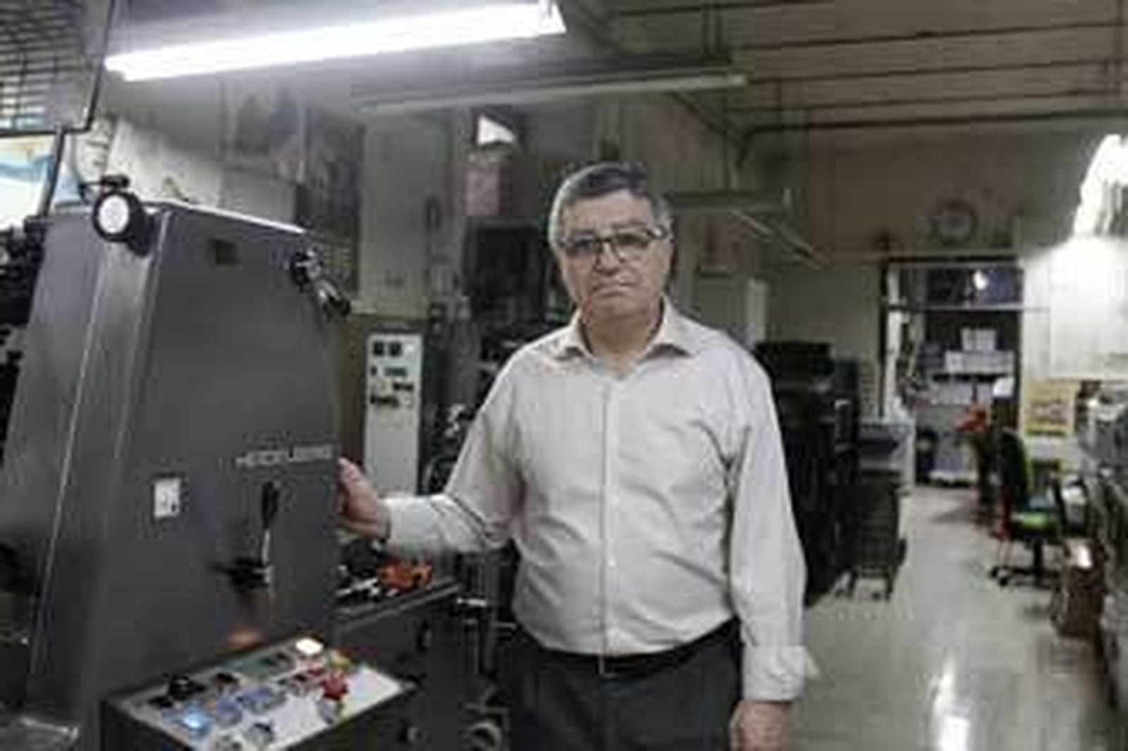 Salvador Repeto junto a una máquina Minerva de aspa, la más antigua de las que funcionan en el taller. /Lourdes de Vicente