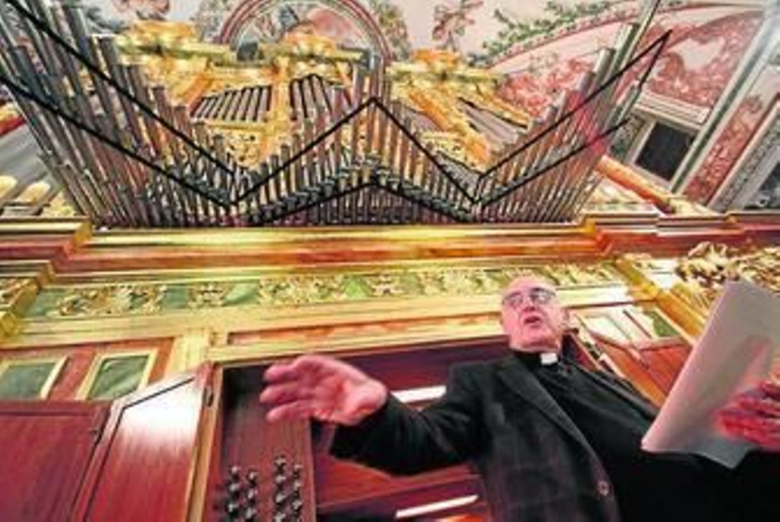 El padre José Enrique Ayarra, ante el órgano de la iglesia de los Venerables.