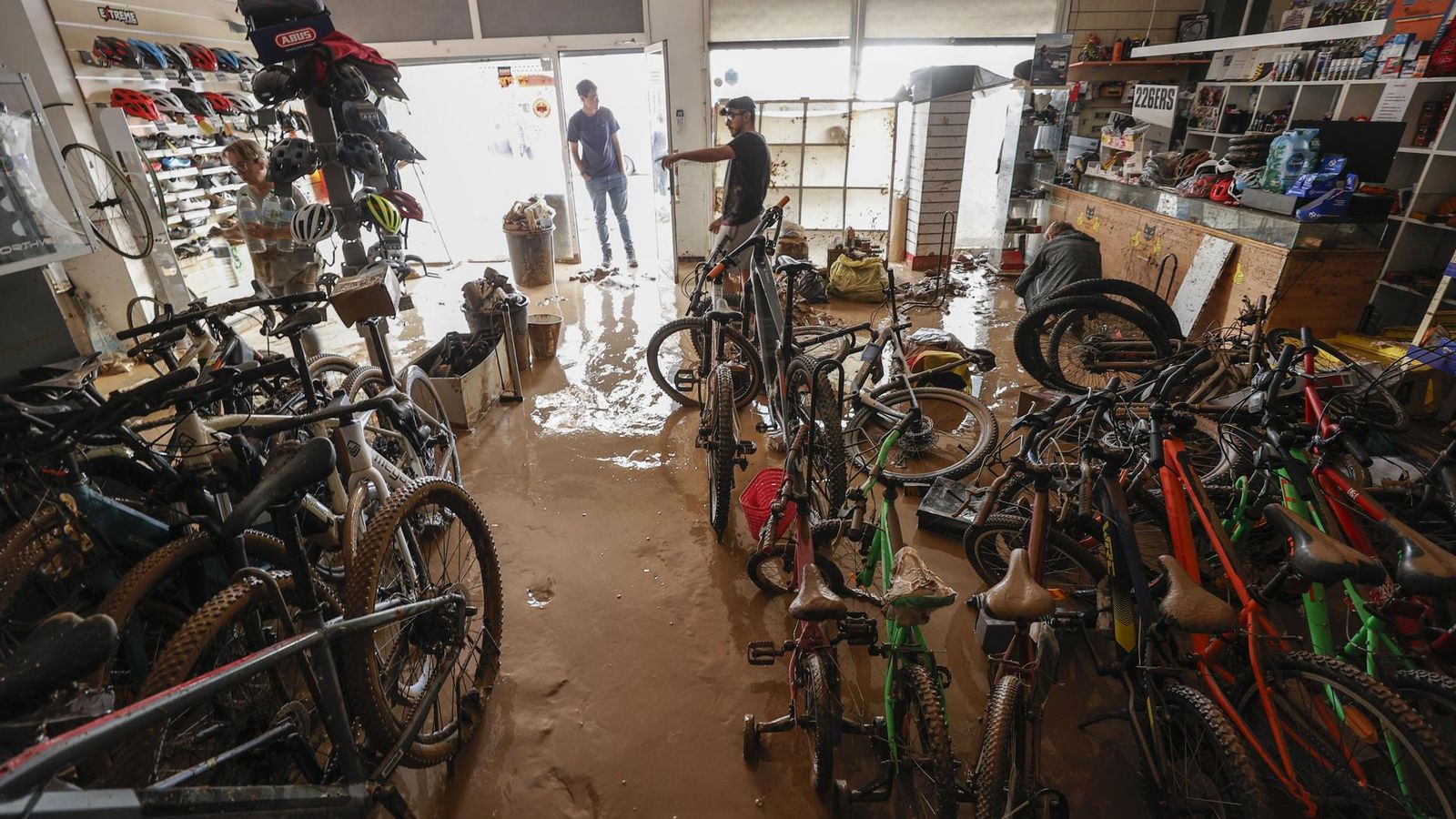 Varias personas evalúan los destrozos causados en el interior de su comercio en la localidad valenciana de Catarroja.