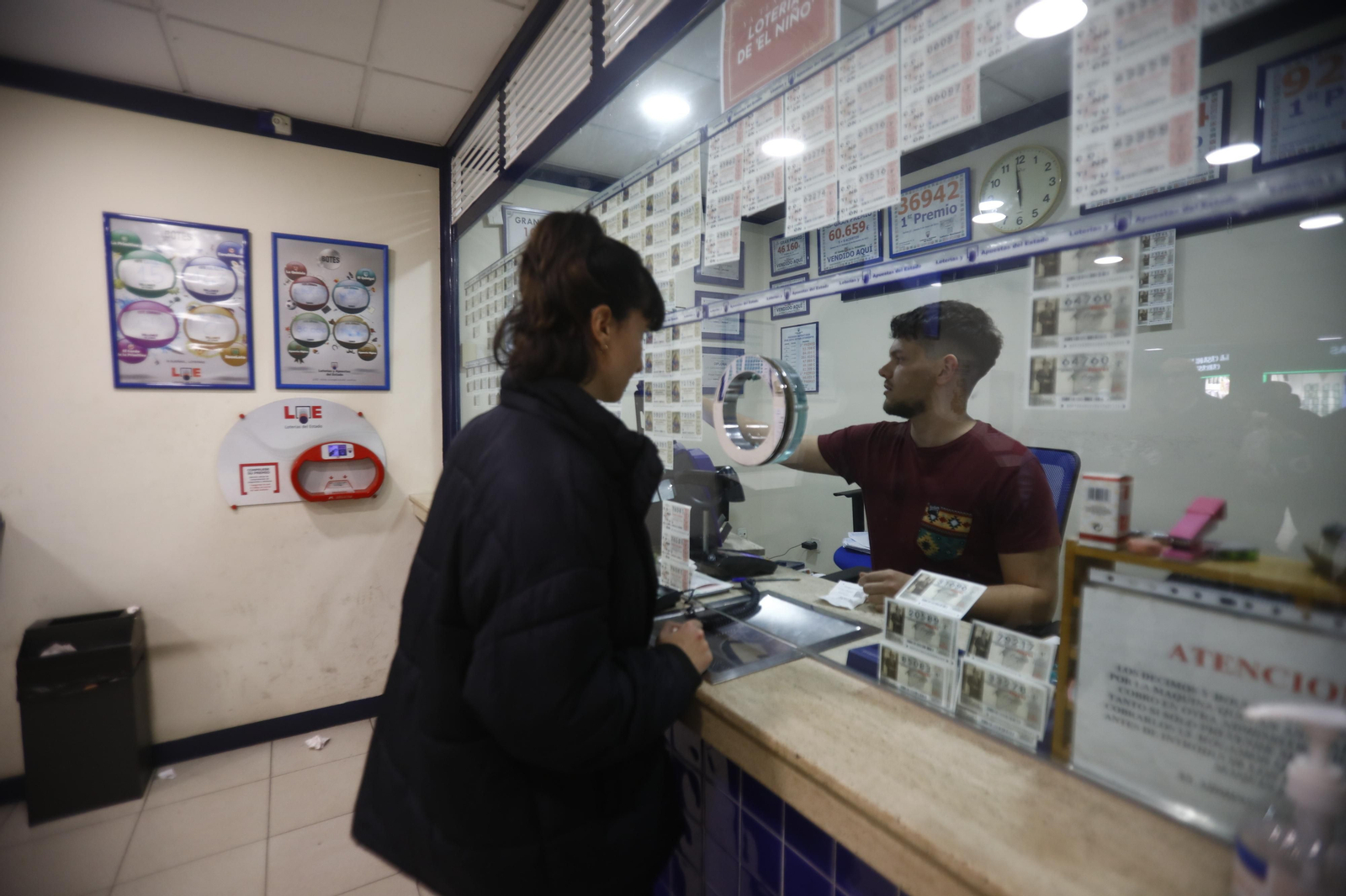 Una mujer compra en una administración de lotería. Una mujer compra en una administración de lotería.