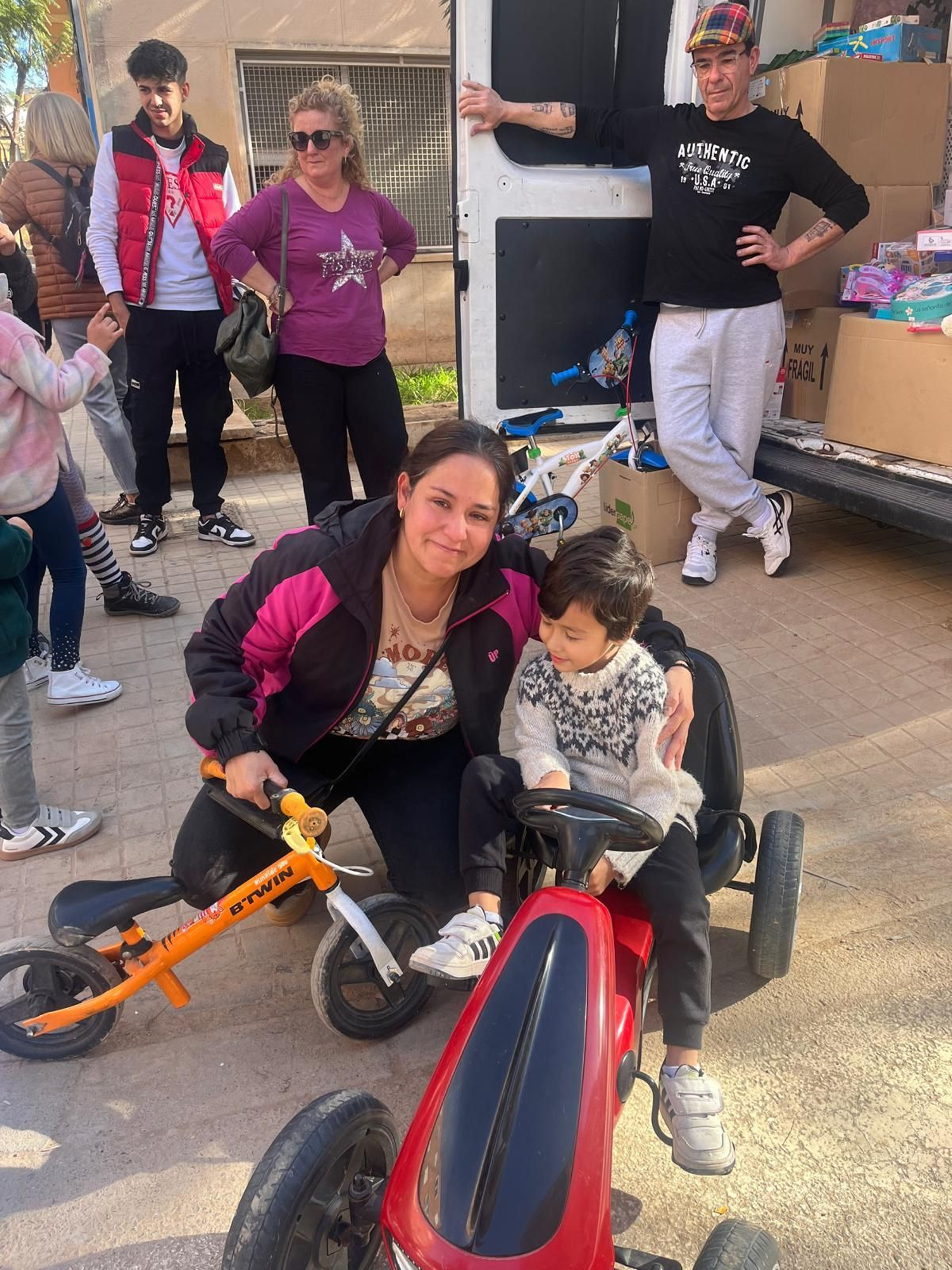 Un pequeño recibe un juguete por parte de los voluntarios jerezanos.
