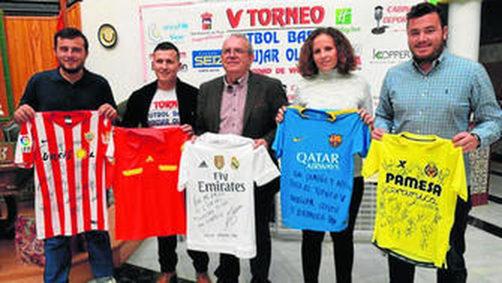 Bonilla y los organizadores del evento posan con algunas de las camisetas de equipos nacionales y de Primera División durante la presentación del V Torneo de Fútbol 7 Juan Andújar Oliver.