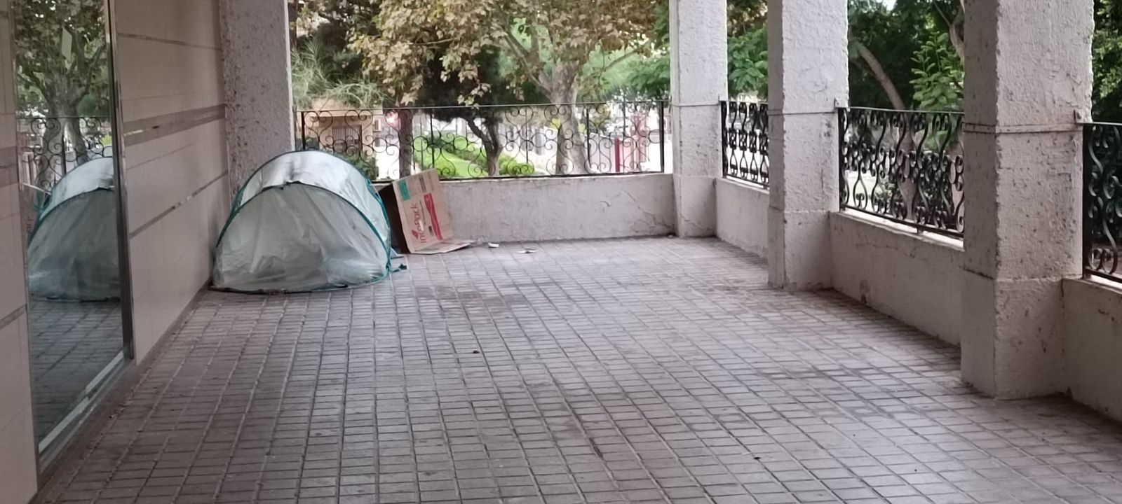 Una tienda de campaña ofrece refugio a una persona sin hogar en uno de los soportales de Nueva Andalucía.