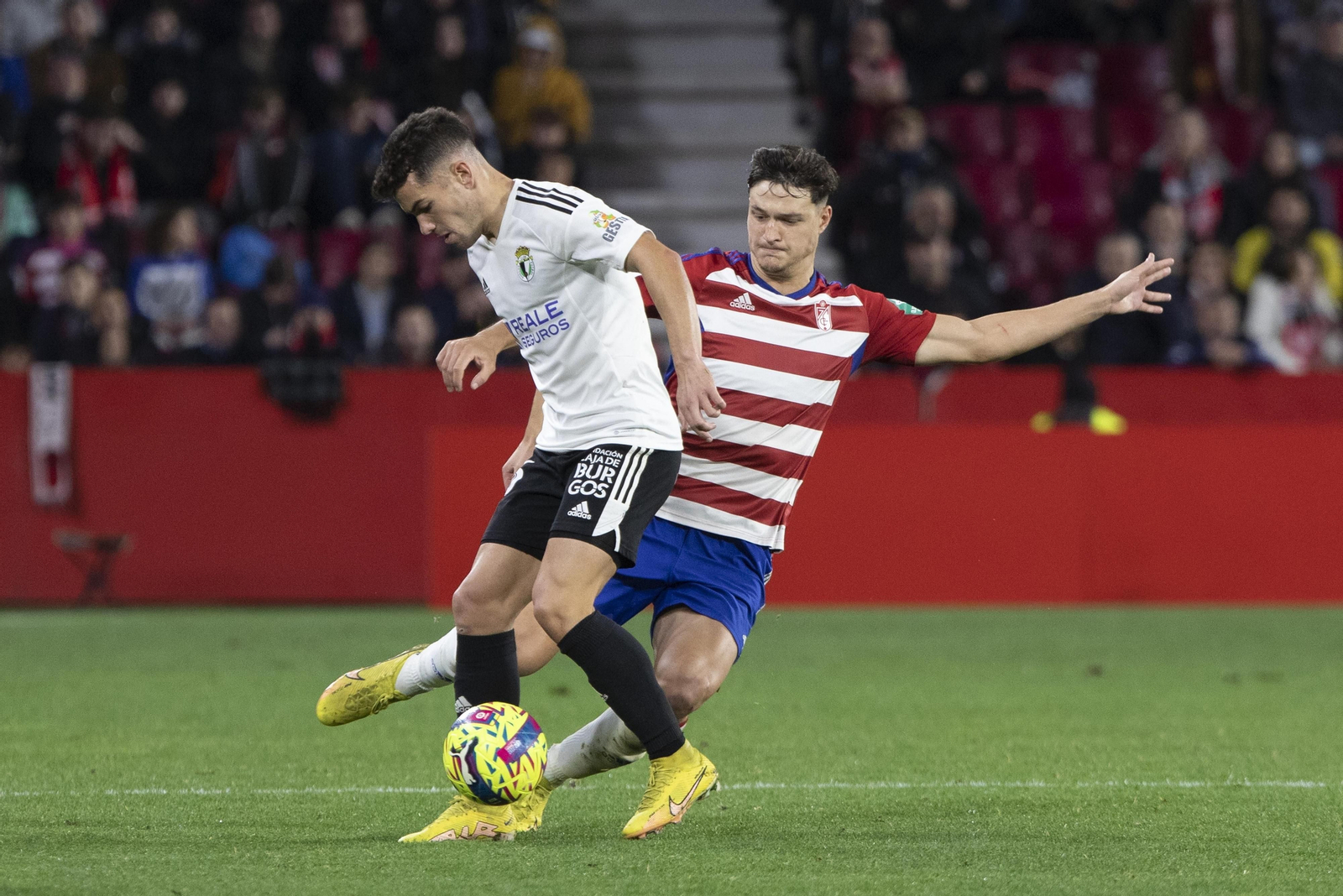 Miguel Rubio trata de tocar el balón ante la oposición del jugador del Burgos Curro.