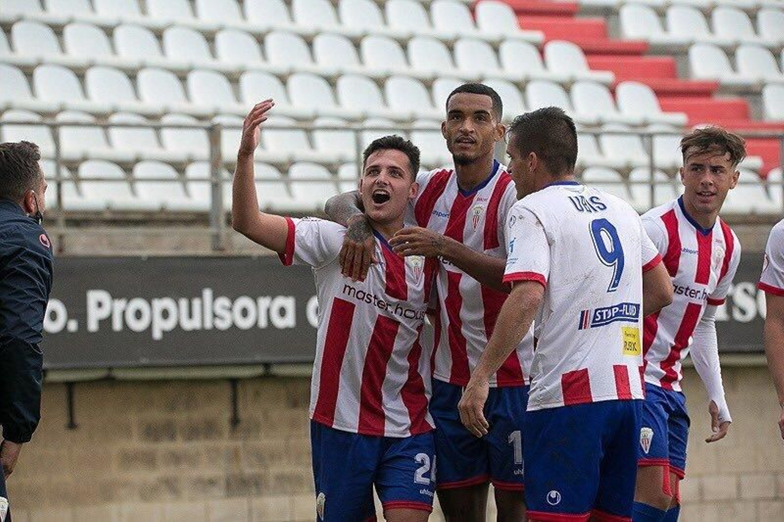 Juan Serrano festeja, abrazado por Robin, su gol al Cádiz B.