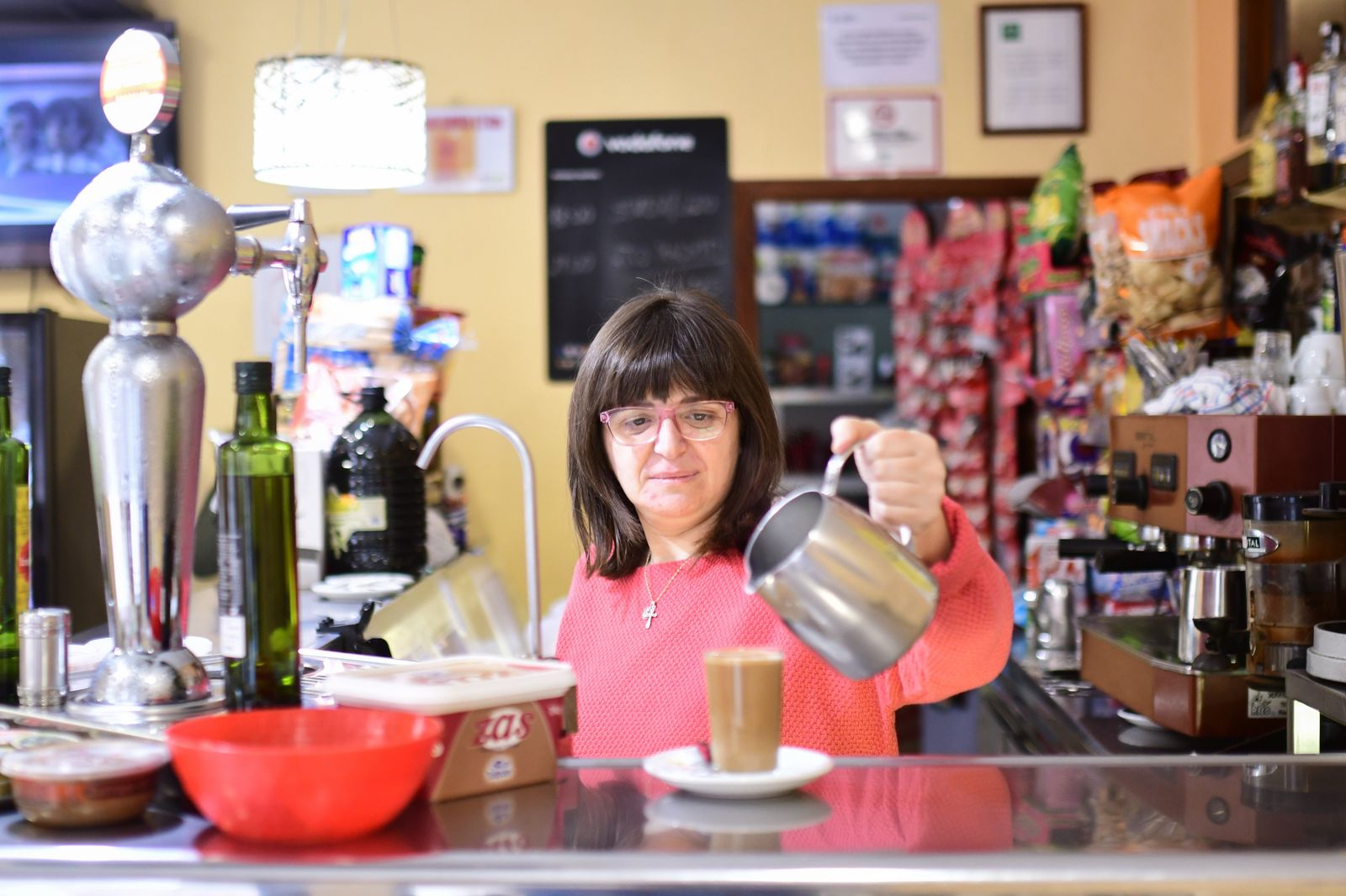 Manoli Sicilia sirve un café con leche en su cafetería.