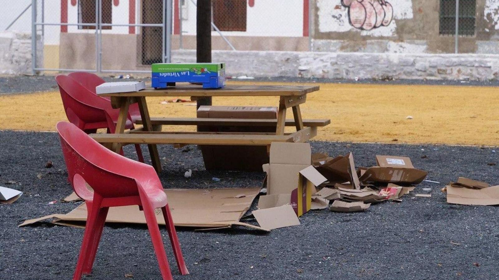 Sillas de plástico y basura acumuladas en el solar.