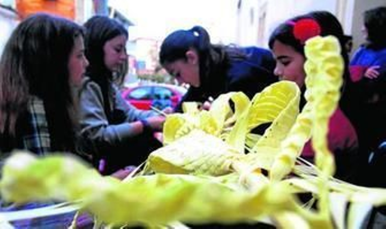 1. Una de las palmas rizadas para el Domingo de Ramos, a punto de concluir su confección. 2. La torre de San Pedro es testigo del rizado de las palmas. 3. Un grupo de hermanas de la Hermandad de la Borriquita, en las labores del rizado de las palmas que vienen realizando a las puertas de su casa.