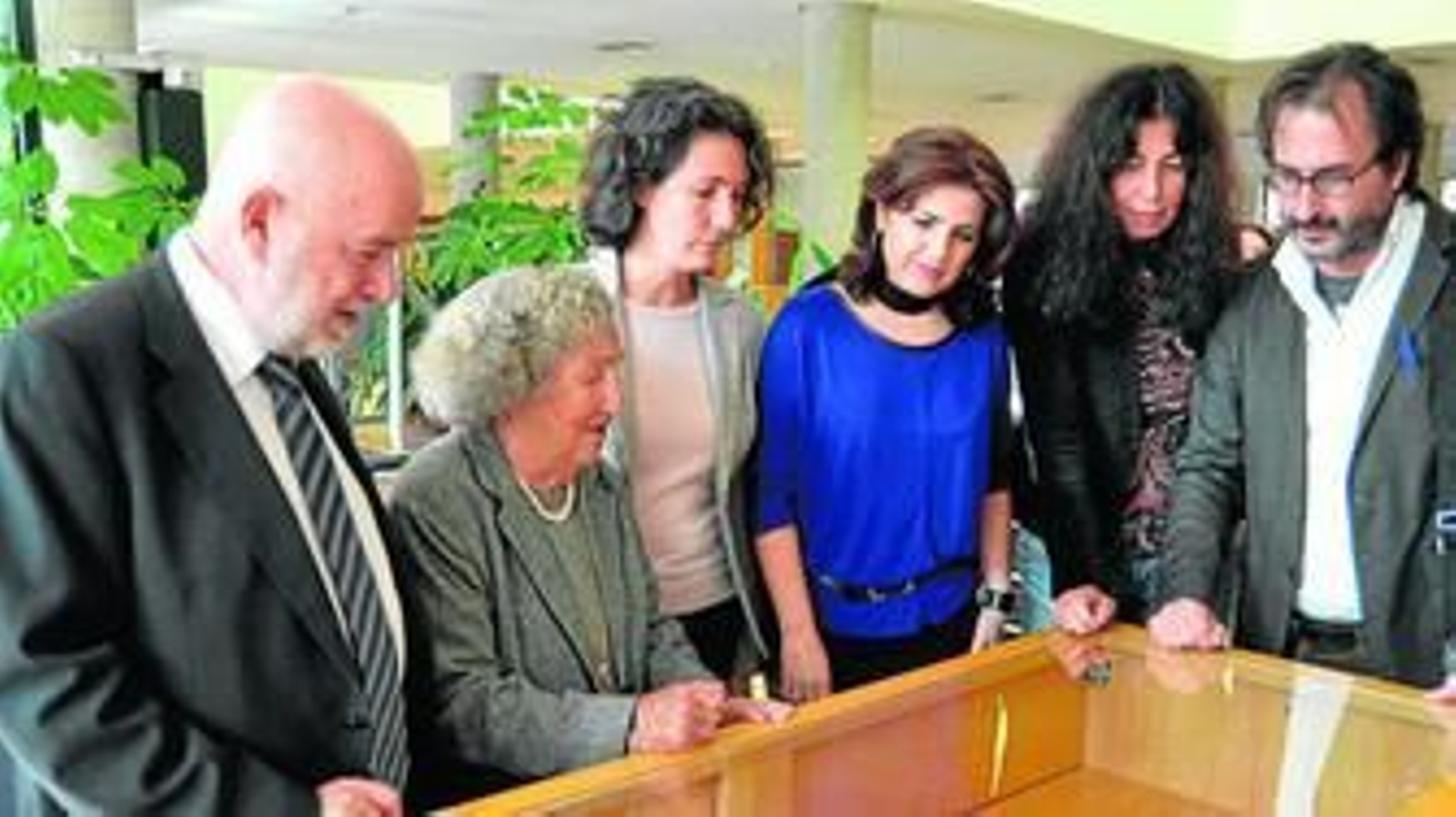 Molina junto a la viuda de Siles y varios profesores de la Universidad viendo los fondos.