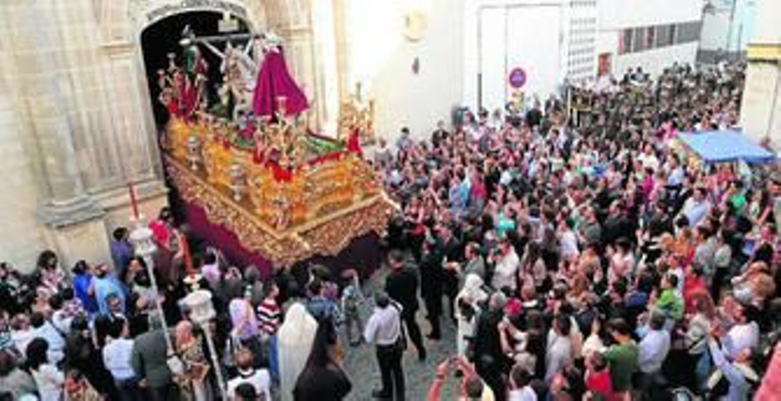 La difícil salida del paso de misterio de la hermandad de la Lanzada desde la basílica del Carmen Coronada, con el Cristo bajado, es seguida detenidamente por la multitud que abarrota la plaza.