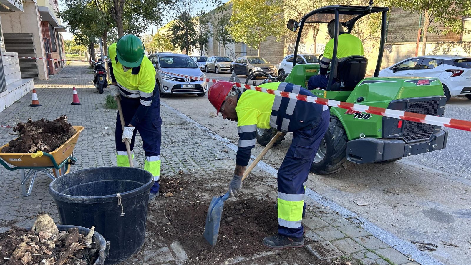 Dos operarios preparan un alcorque para que acoja un nuevo árbol.