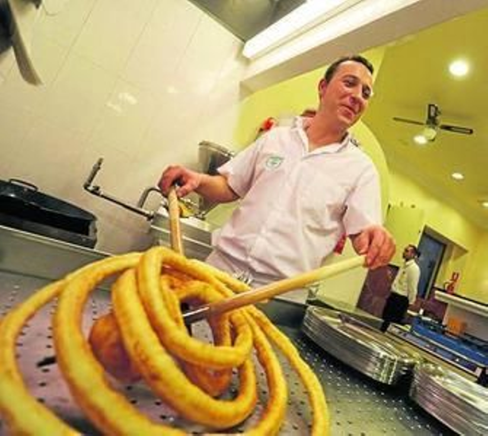 Uno de los cocineros, junto a la máquina de churros.