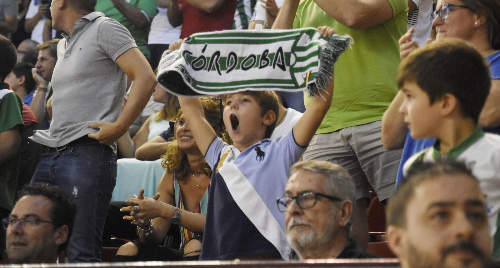 Un joven alza la bufanda del Córdoba Futsal en Vista Alegre.