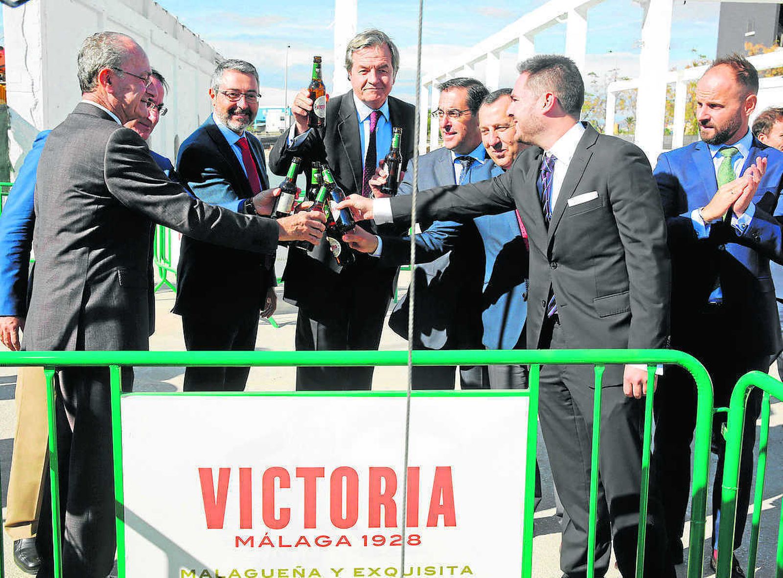 Diversas autoridades malagueñas junto a integrantes de la familia Franquelo brindan con un botellín de Victoria.