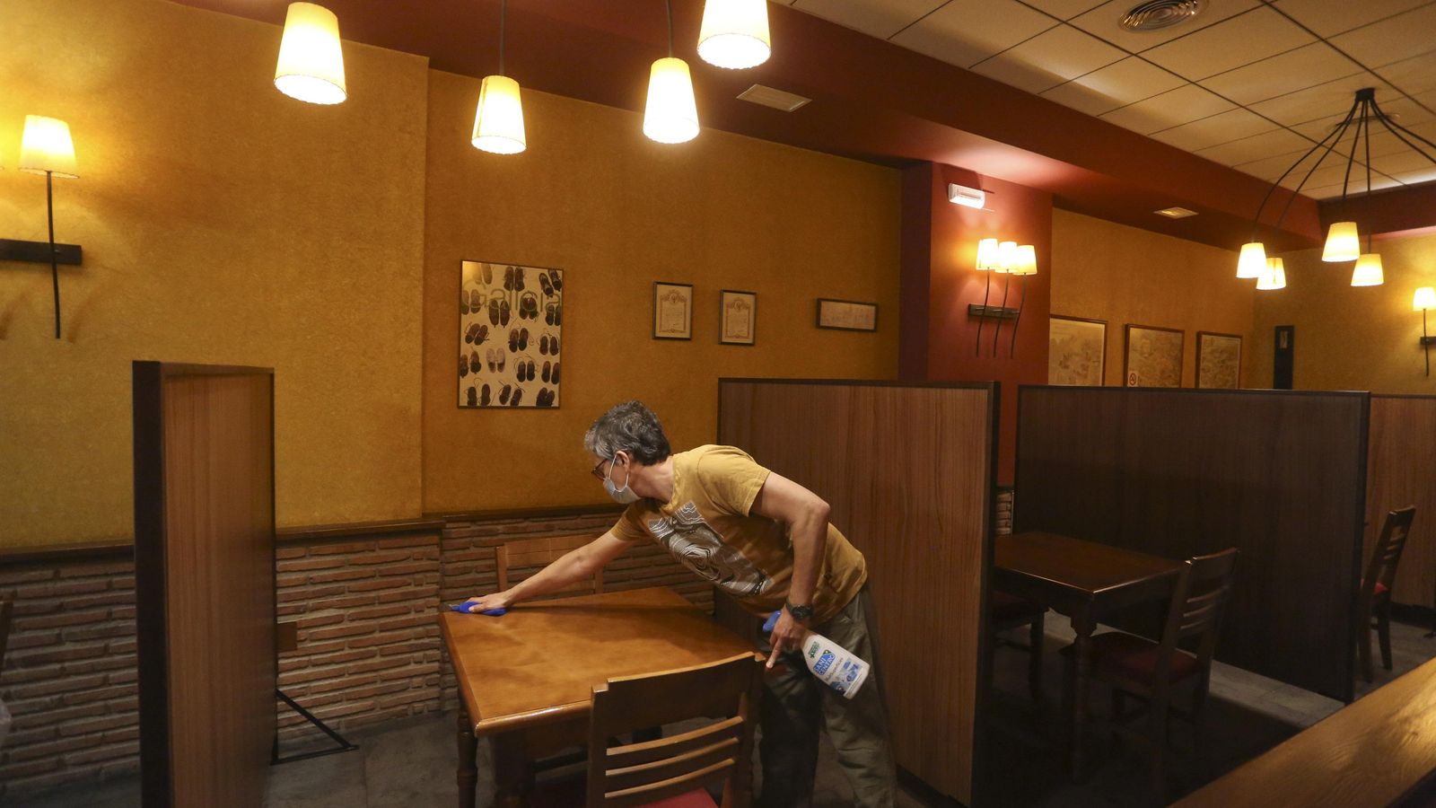 Un trabajador limpia una de las mesas.