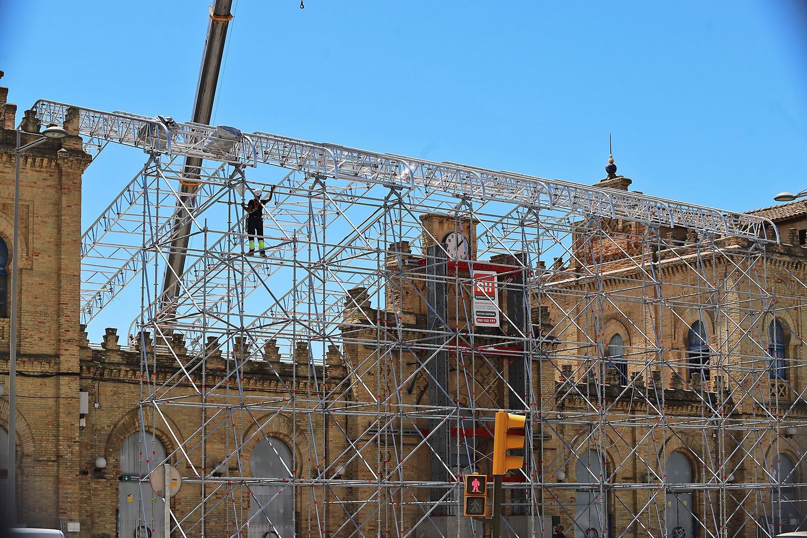 Los operarios colocan la estructura superior de la cubierta provisional para la antigua estación de Huelva.