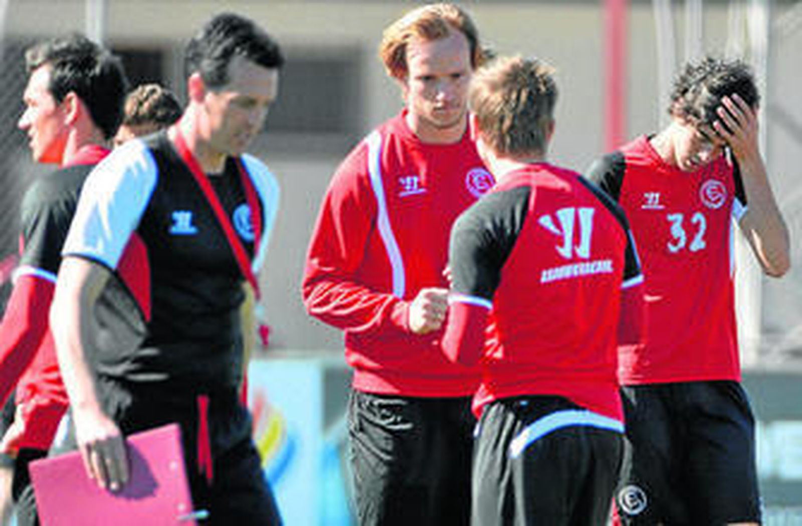 Unai Emery, difuminado, pasa por delante de Rakitic, Marko Marin y Carlos Fernández.