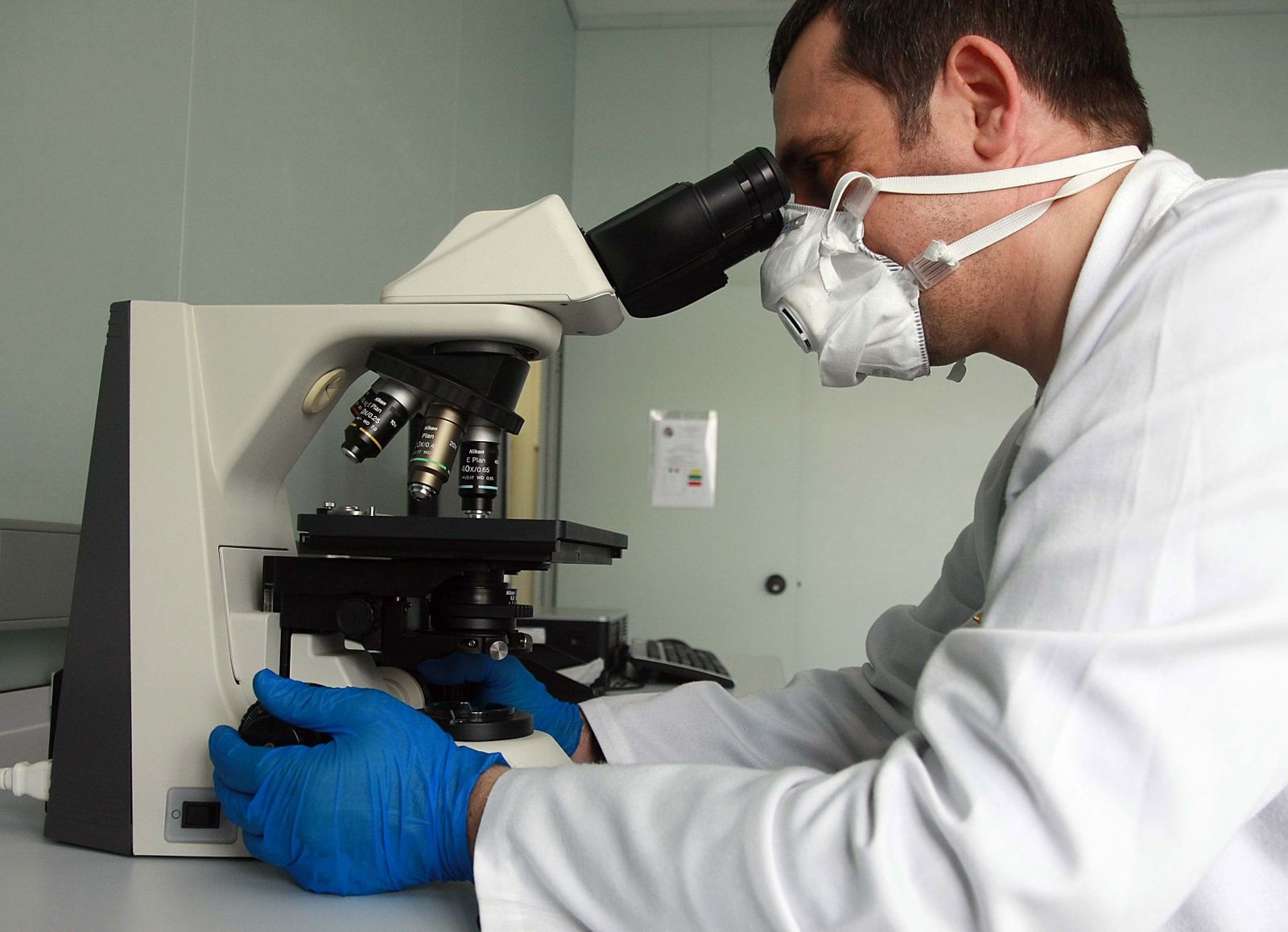 Imagen de archivo de un investigador mirando a través de un microscópio