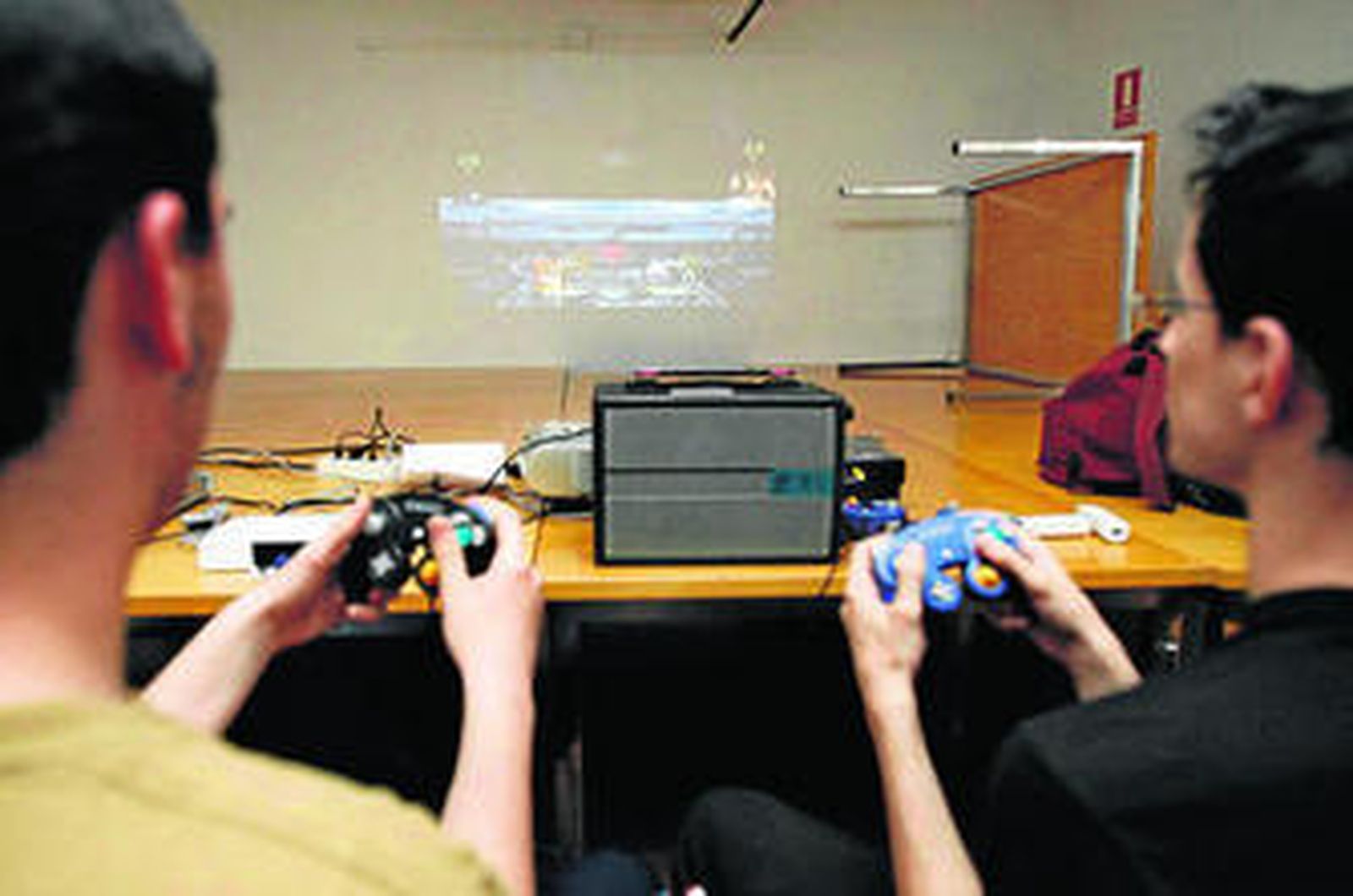 Dos jóvenes juegan con su consola.