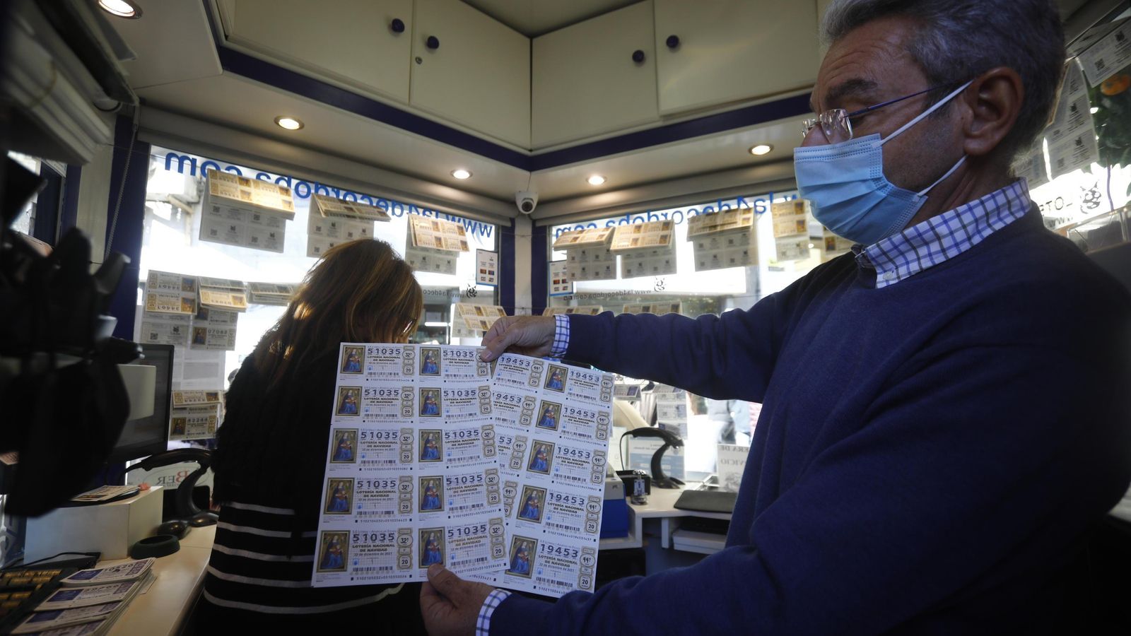 El lotero Juan Francisco León enseña varios décimos de lotería de Navidad en la administración número 4