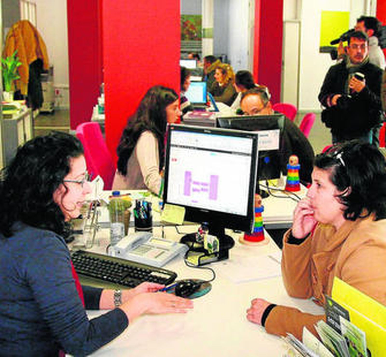 Varios empleados asesoran a emprendedores en un CADE.