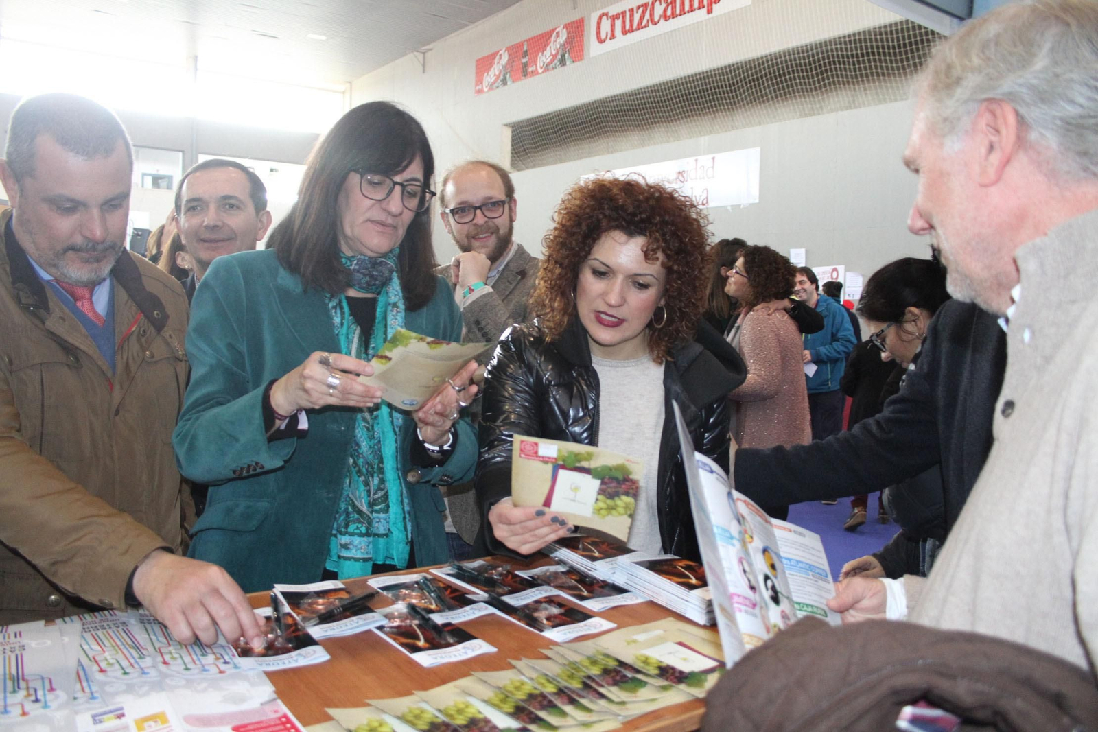 La rectora hojea unos folletos acompañada por otras autoridades.