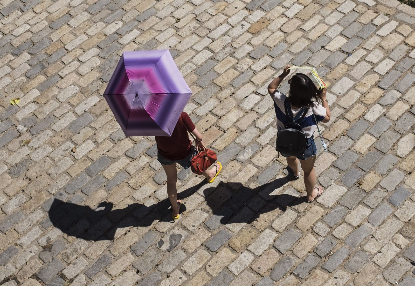 Dos paseantes se protegen del calor en Sevilla.