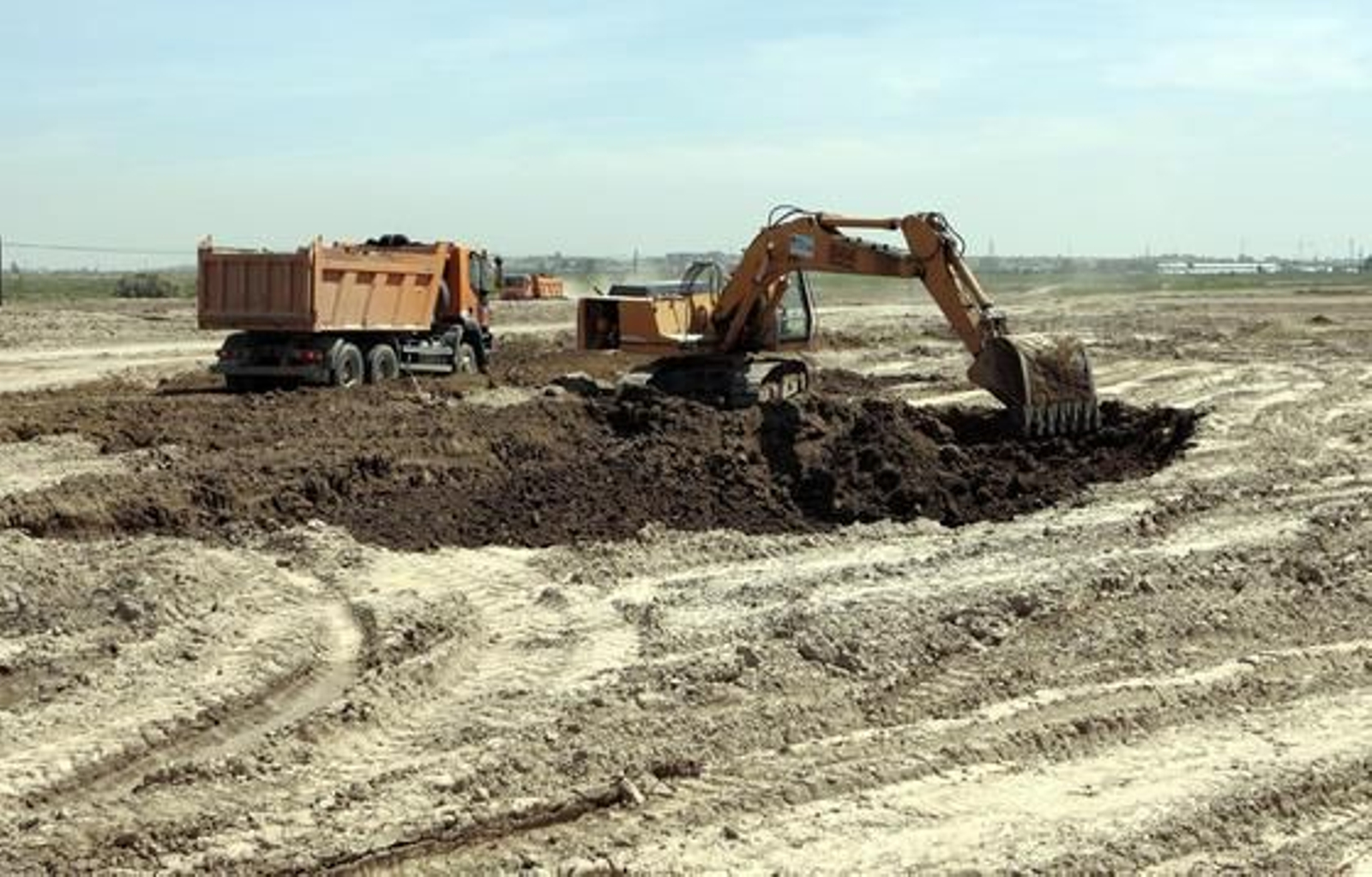 Una grúa remueve la tierra, y al fondo dos camiones de la obra.  Foto: Juan Carlos Muñoz