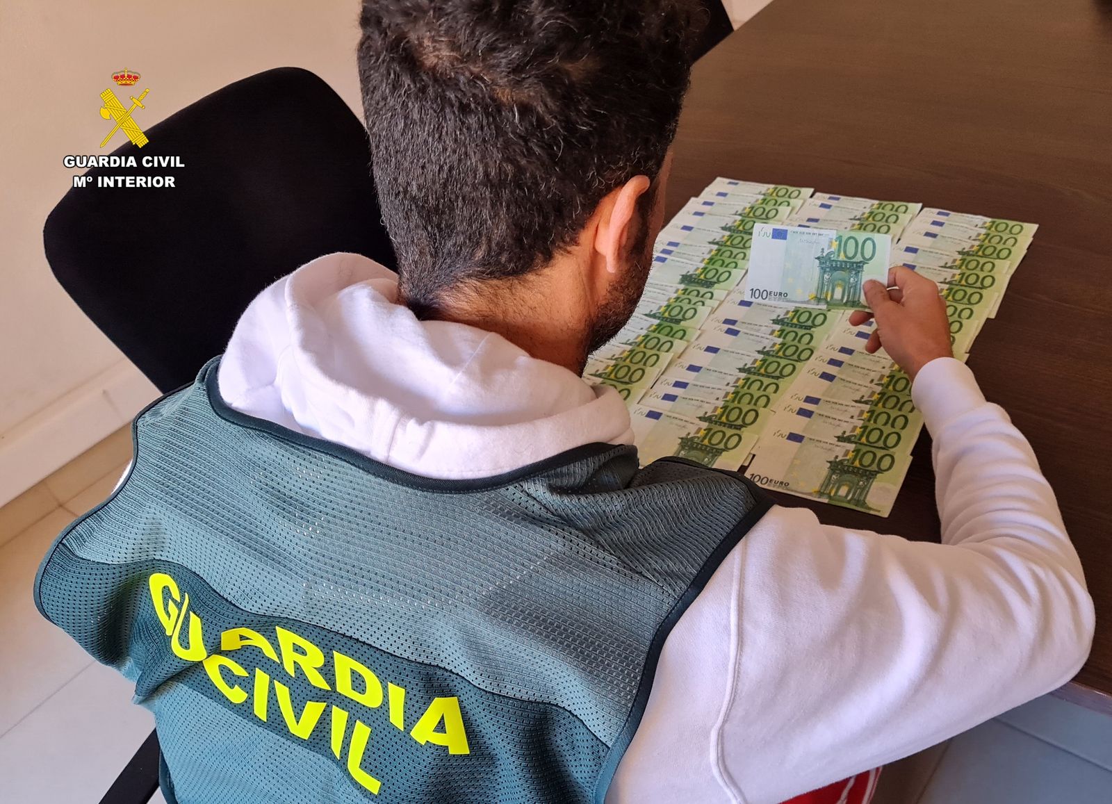 Un agente con los billetes falsificados.