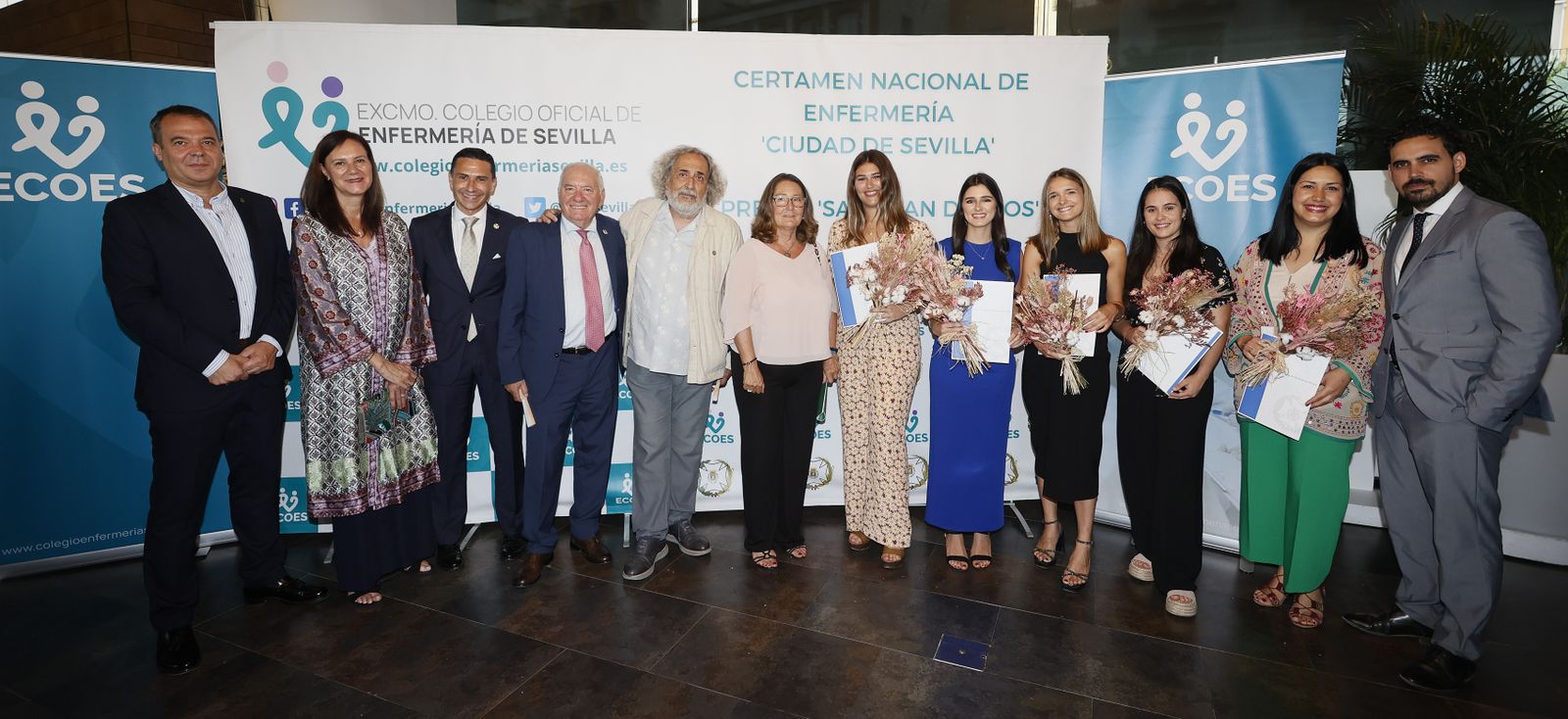 De izq. a dcha.:  Federico Gil, director gerente de la Ciudad San Juan de Dios; Carmen Bustamante, directora general del SAS; Víctor Bohórquez, presidente del  Excmo. Colegio Oficial de Enfermería de Sevilla; Florentino Pérez Raya, presidente del Consejo General de Enfermería; José Chamizo, presidente de la Fundación Sevilla Acoge (premio San Juan de Dios); Regina Serrano, delegada territorial de Salud y Familias; María Aguilar, autora tercer premio Certamen; María Viera, Accésit Enfermería Joven; María Inmaculada Henares, autora segundo premio Certamen;  Paula Betés, primer premio del Certamen; María del Rosario Martínez, coautora tercer premio; y Manuel Pabón, coautor segundo premio del Certamen.