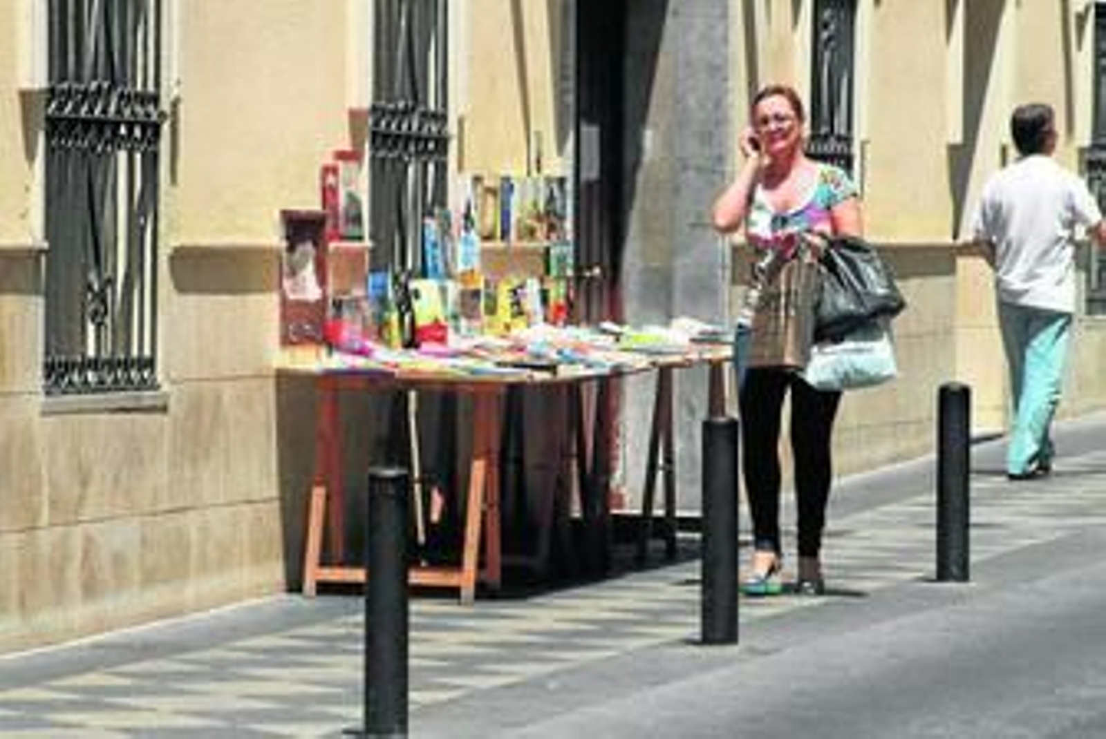 El puesto de libros en la calle, pasando casi desapercibido entre los vecinos que pasean por su lado.
