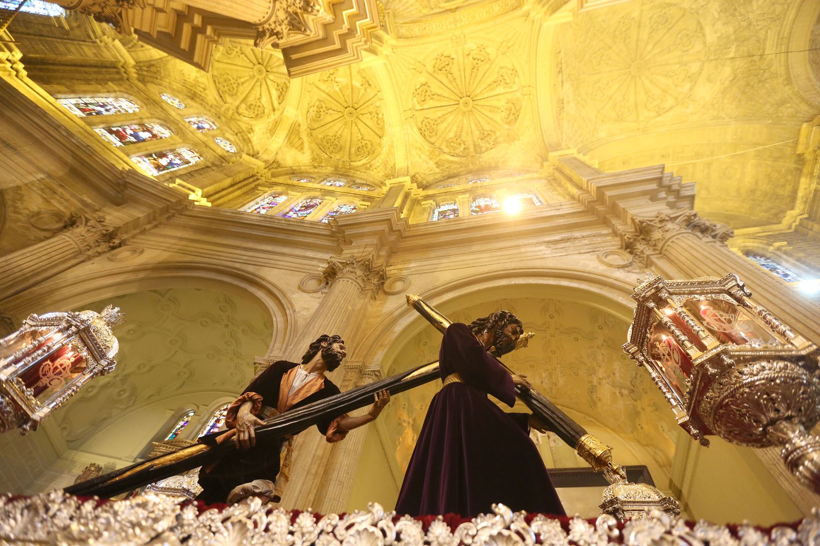 El Cristo del Perdón y su grupo escultórico surgen en contraluz ante la basílica de la Esperanza.