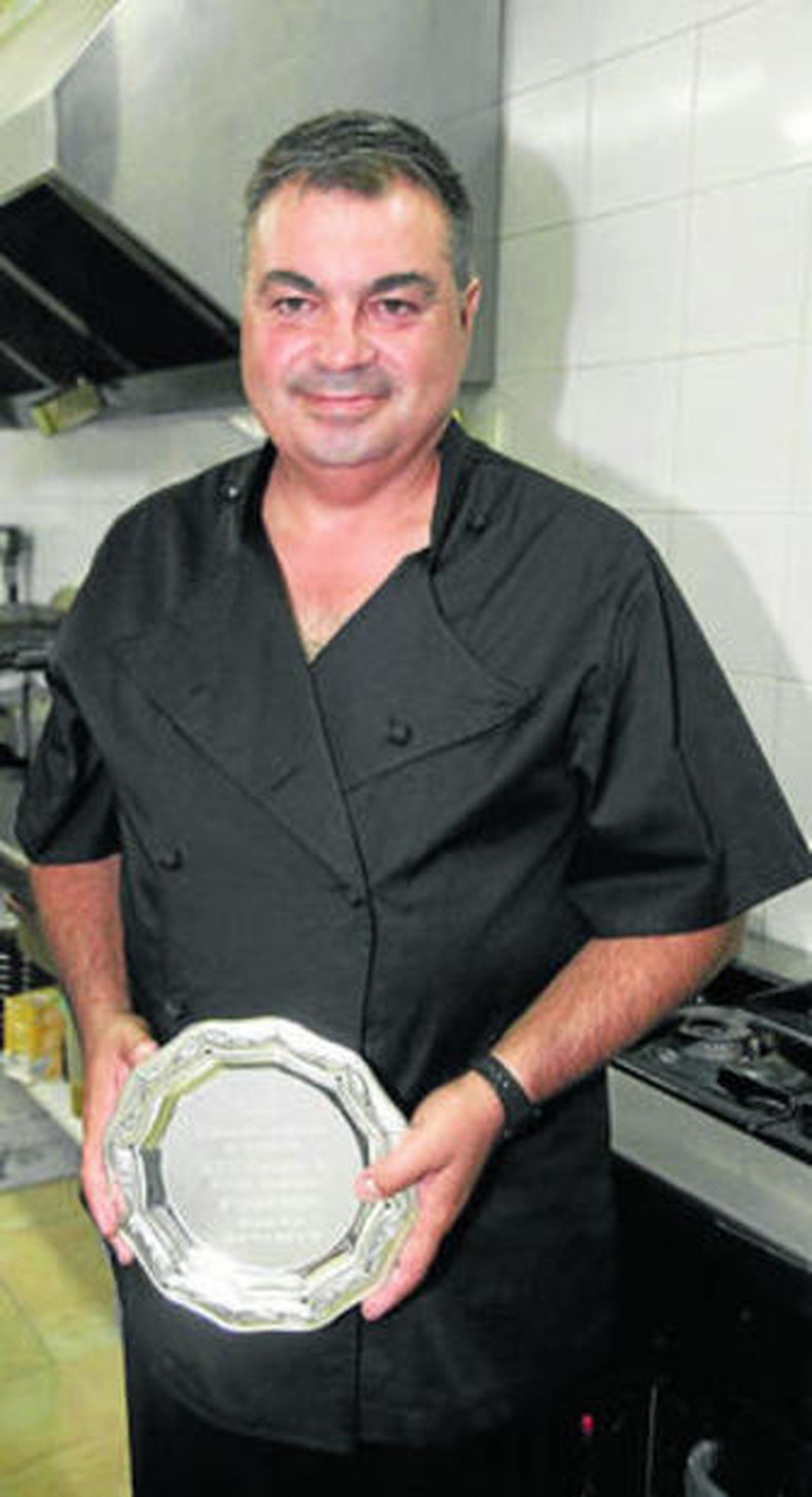 Hispano muestra el premio como primer clasificado.