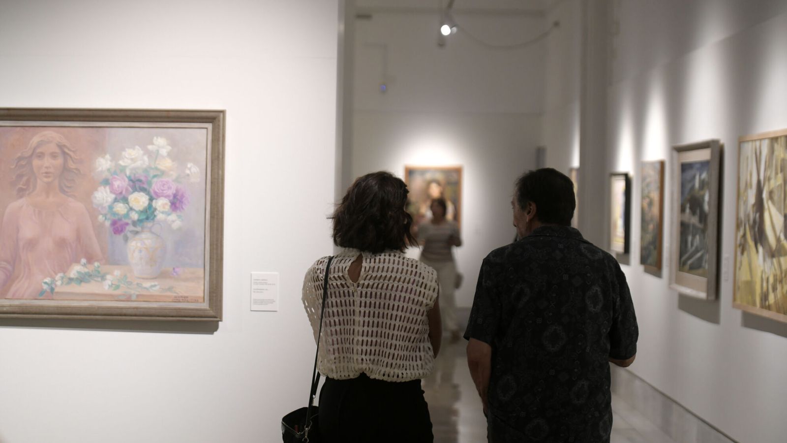 Dos visitantes contemplan las imágenes.