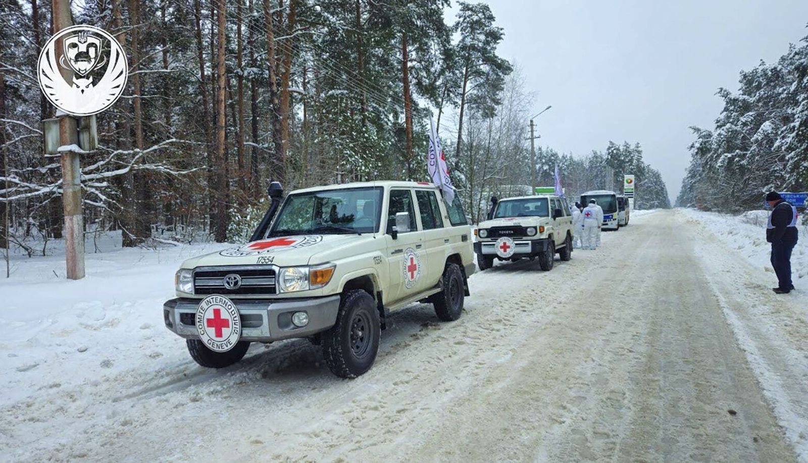 Vehículos de Cruz Roja participan en el intercambio de cuerpos de soldados.