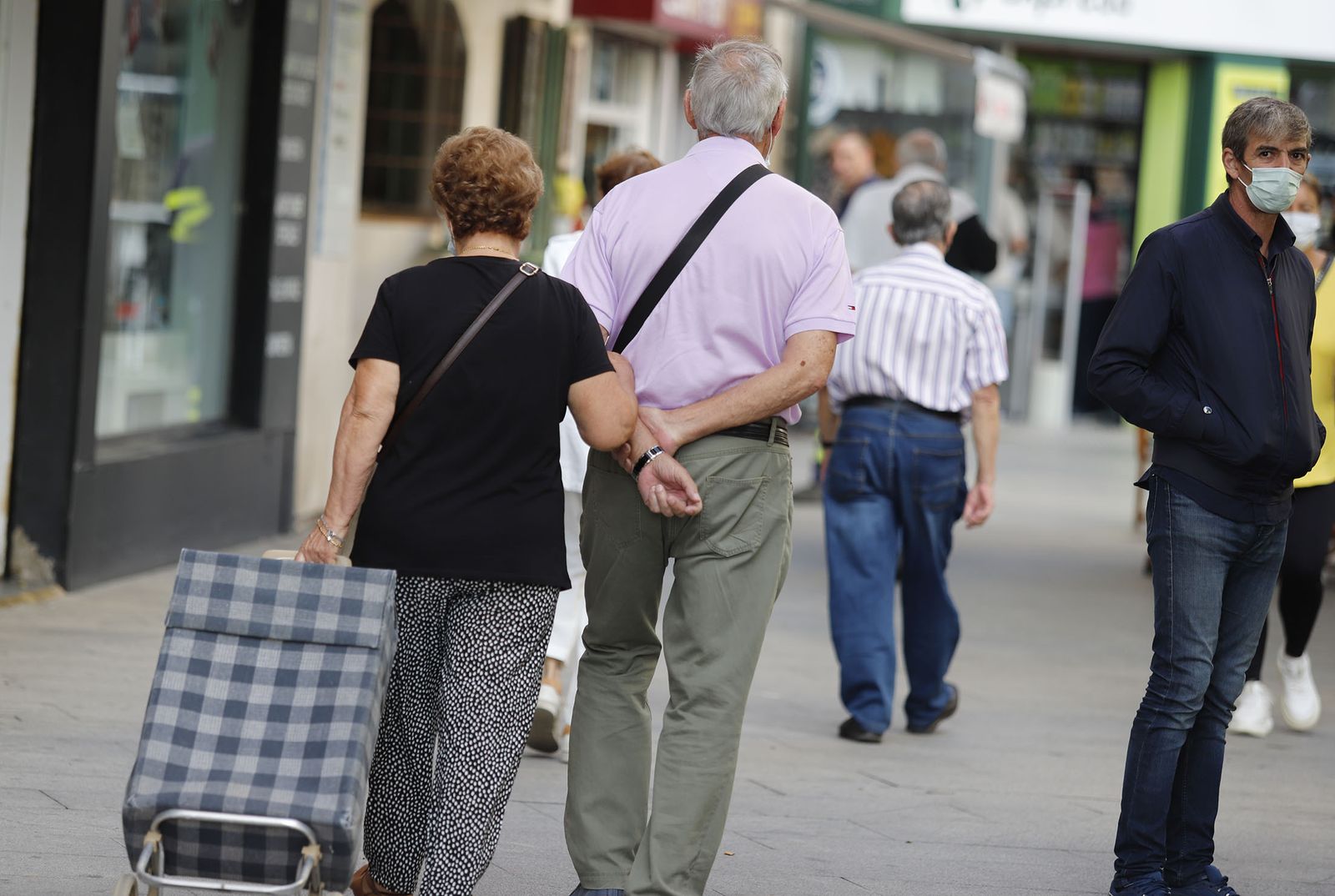 Una pareja pasea agarrada por la capital onubense.